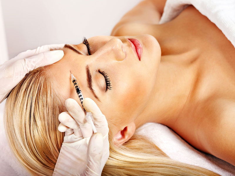 Botox-Injektion am Kopf einer Frau